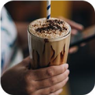 man drinking a milkshake from a straw in a coffee shop
